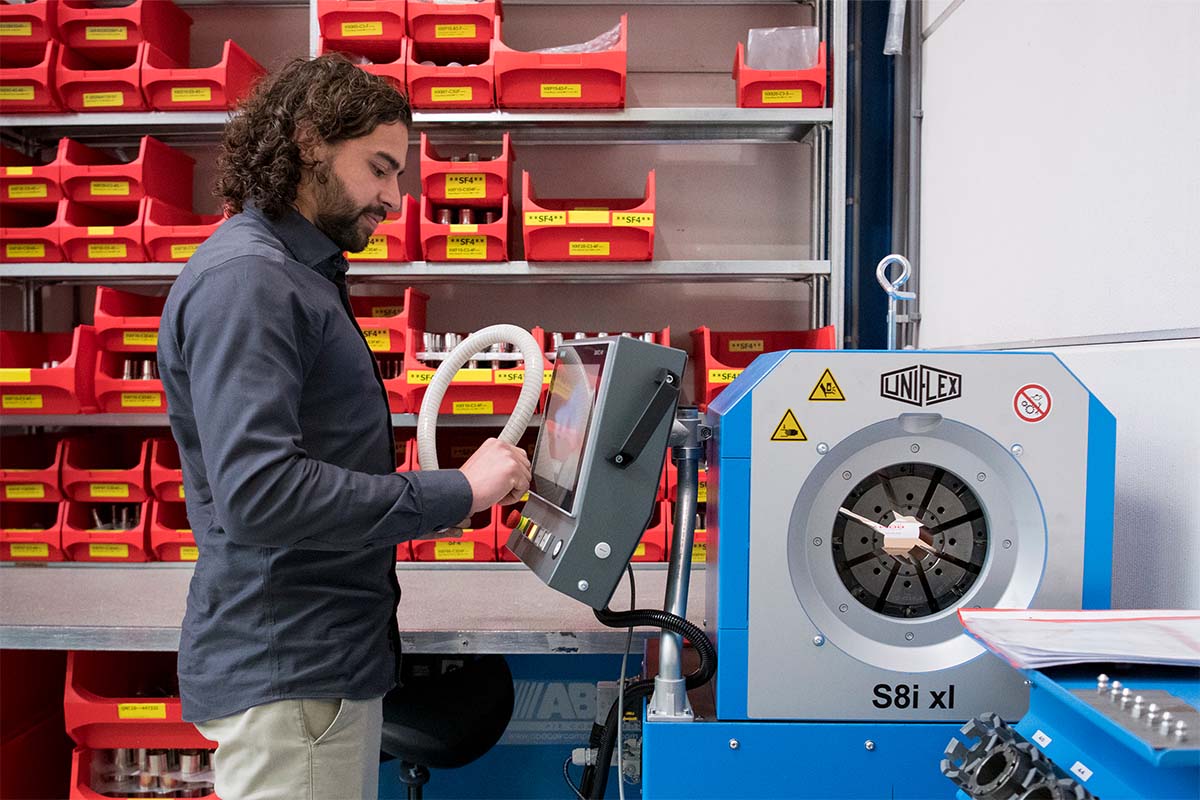 Romynox employee working on a high-purity hose assembly in a cleanroom environment.